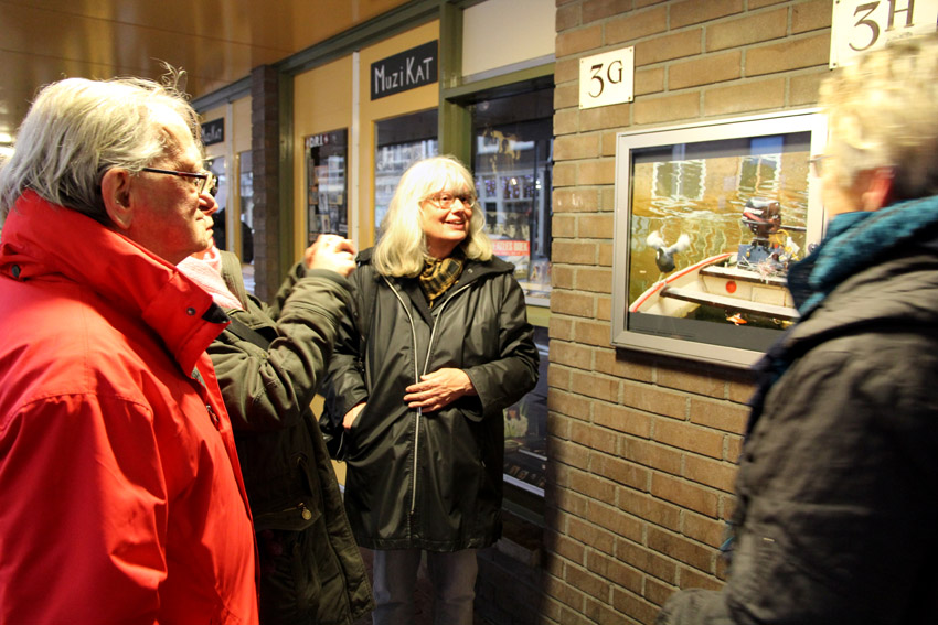 Bij de vitrines in de Sint Antoniesbreestraat wordt de expositie van foto's geopend met een rondleiding